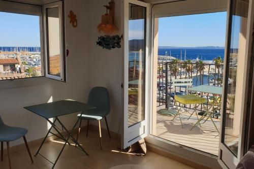 une chambre avec un balcon avec une table et des chaises dans l'établissement Balcon des îles d'Or - T2 seafront historic center, au Lavandou
