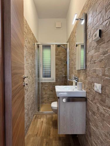 a bathroom with a sink and a shower and a toilet at Petra House in Porlezza