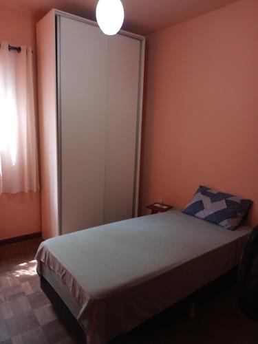 Schlafzimmer mit einem Bett und einer großen Schiebetür in der Unterkunft Alojamento do João in Lagoa Santa