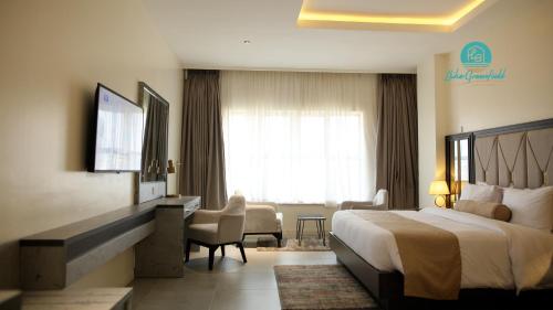 a hotel room with a bed and a living room at Lake Greenfield Hotel and Towers in Abuja