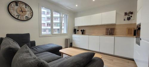 un salon avec un canapé et une horloge au mur dans l'établissement 