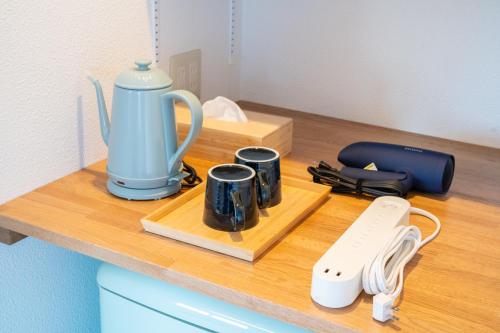 a counter with a tea kettle and mugs on it at Blue Star Hotel in Chikuni