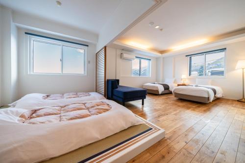 a large bedroom with two beds and a blue chair at Blue Star Hotel in Chikuni