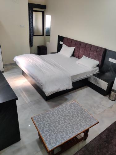 RāipurHotel Anand shree的一间卧室配有一张床和一张茶几