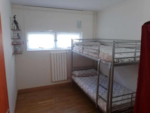 Cette petite chambre dispose de 2 lits superposés et d'une fenêtre. dans l'établissement Appartement cosy 1 chambre, 6 pers. proche centre et pistes - FR-1-404-89, à La Mongie
