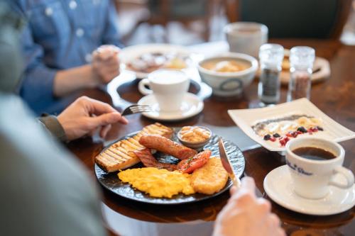 a table with a plate of breakfast food on it at Blue Star Hotel in Chikuni