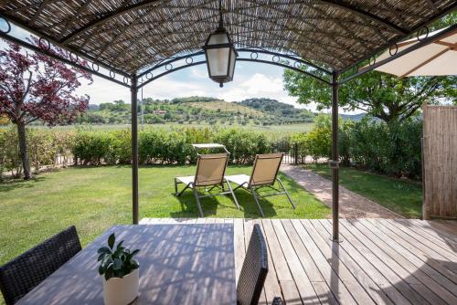 a patio with a table and chairs under a pergola at Podere Vignanova Accommodations & SPA in Castagneto Carducci