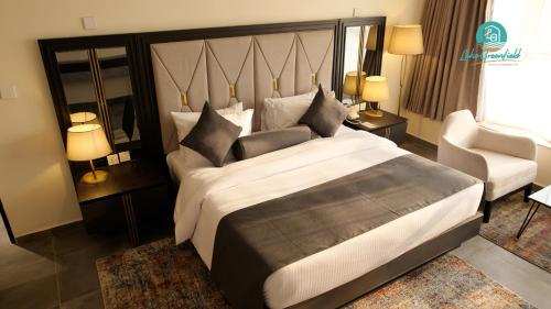 a hotel room with a large bed and a chair at Lake Greenfield Hotel and Towers in Abuja