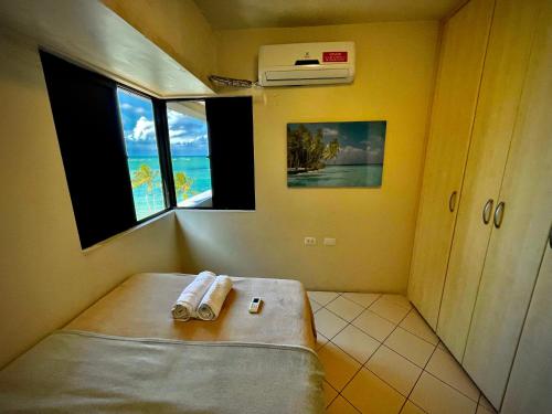 een kamer met een bed met twee handdoeken erop bij BEIRA MAR 2 Quartos com Ar e Cozinha Completa in Maceió