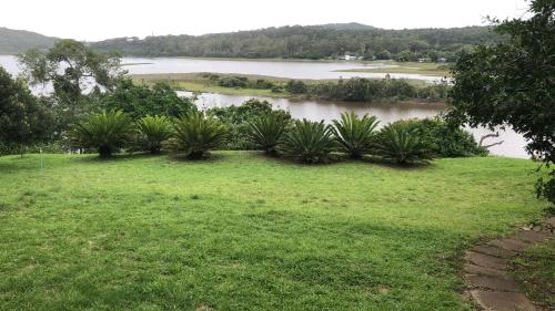 a grassy area with a view of a body of water at East London - Airport - Birder Paradise Units in Gulu