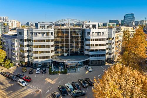 a parking lot with cars parked in front of a building at Crystal Palace Hotel in Bucharest