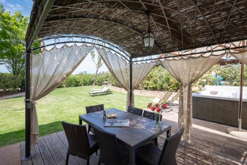 a patio with a table and chairs on a deck at Podere Vignanova Accommodations & SPA in Castagneto Carducci