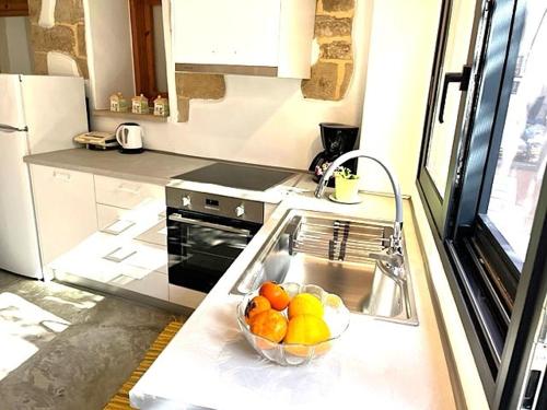 a kitchen with a bowl of fruit in the sink at Lemonia Home in Sirílion