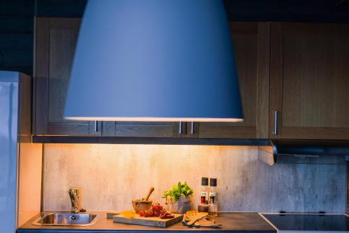 a kitchen with a sink and a blue overhead at Svalbard Hotell | Lodge in Longyearbyen