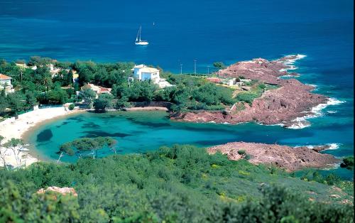 une petite île avec un bateau dans l'eau dans l'établissement Bleu-Estérel, 50m de la plage, appartement 4 personnes, à Saint-Raphaël