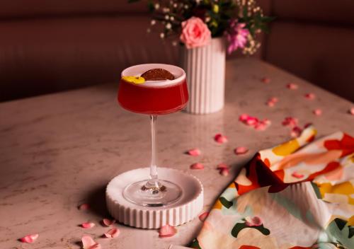 a red drink sitting on a table with confetti at The Morgan Hotel in Dublin