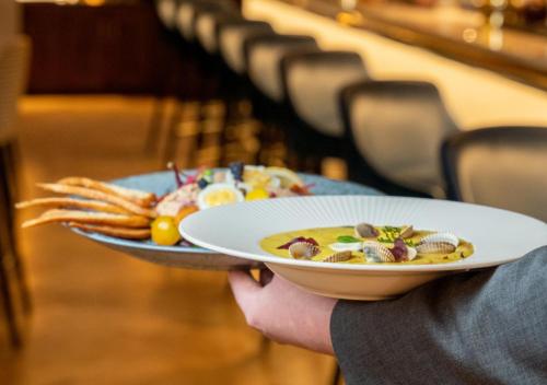 a person holding a plate of food with french fries at The Morgan Hotel in Dublin