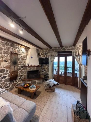 a living room with a couch and a stone fireplace at Angel House Greystone Villa Polydrossos in Polydrossos