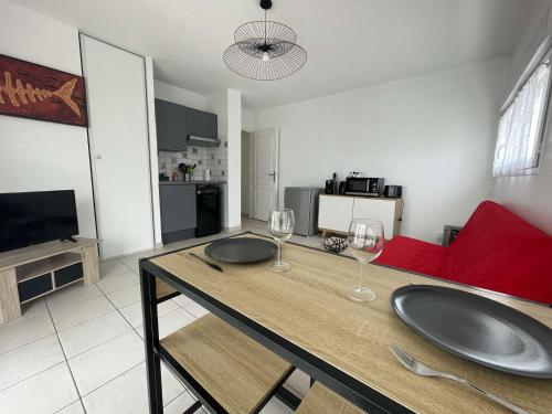 - un salon avec une table et deux verres à vin dans l'établissement Appt 2 pièces LA ROCHELLE - LR150-216, à La Rochelle