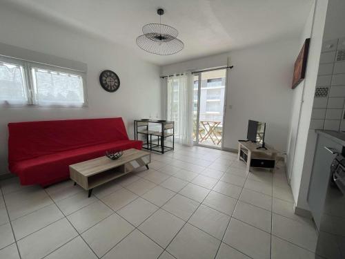 un salon avec un canapé rouge et une table dans l'établissement Appt 2 pièces LA ROCHELLE - LR150-216, à La Rochelle