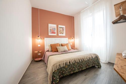 a bedroom with a bed with orange walls at aMoneglia, 2 minutes walk to the beach, PVT PARK in Moneglia
