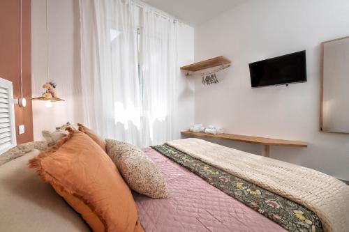 a bedroom with a bed with a television on the wall at aMoneglia, 2 minutes walk to the beach, PVT PARK in Moneglia