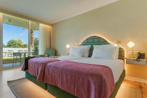a hotel room with a large bed and a balcony at Pestana Quinta Perestrello in Funchal