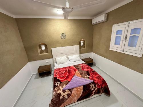 Un dormitorio con una cama con una manta floral. en Tuya House Luxor, en Luxor
