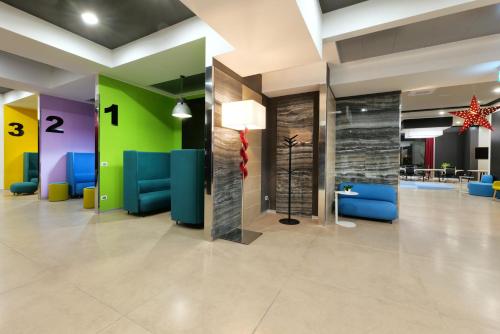a lobby with blue chairs and a green wall at LHI Healthy Hotel Lecce in Lecce