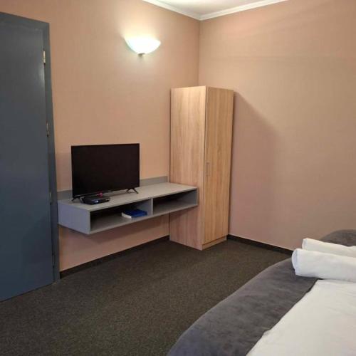 a hotel room with a television and a cabinet at Hotel Unicornis in Eger