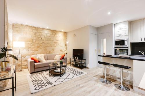 une cuisine et un salon avec un canapé et une table dans l'établissement Charmant 2 pièces - Plein Centre de Paris, à Paris