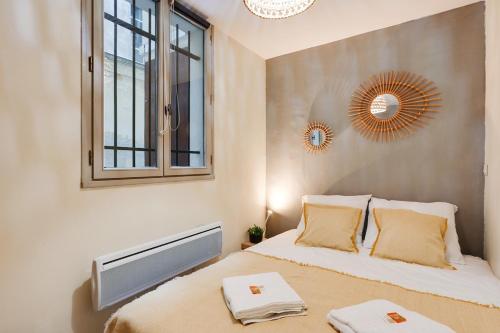 une chambre avec un lit, une fenêtre et un miroir dans l'établissement Charmant 2 pièces - Plein Centre de Paris, à Paris