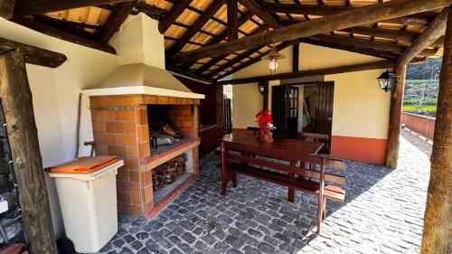 a living room with a brick fireplace and a wooden table at Casa dos Lamaceiros in São Vicente