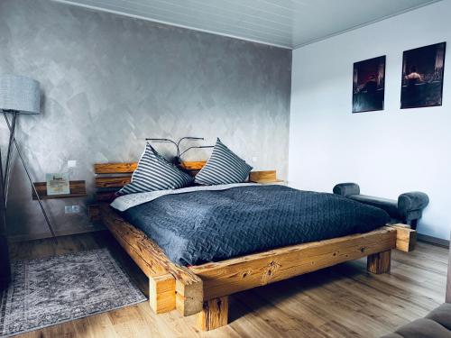 a bedroom with a wooden bed with blue pillows at Ferienwohnung Bavaria Weekend in Marktoberdorf
