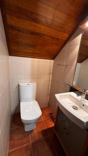 a bathroom with a toilet and a sink at Casa dos Lamaceiros in São Vicente