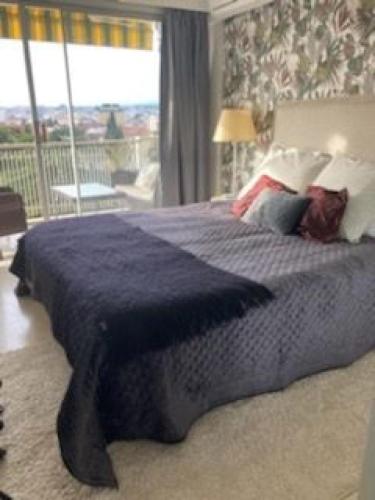 une chambre avec un grand lit avec une couverture bleue dans l'établissement Belle terrasse près du Martinez et des plages!, à Cannes