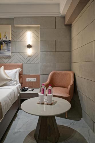 a room with a bed and a table and a chair at Golden Plaza in Ahmedabad
