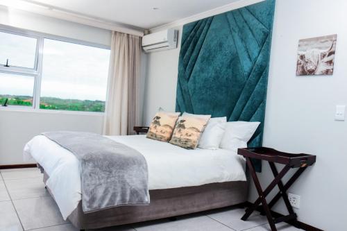 a bedroom with a bed and a large window at Santareme Seaviews in Sea Vista