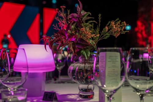 a table with wine glasses and a vase with flowers at Elite Hotel Marina Tower, Spa & Resort in Stockholm