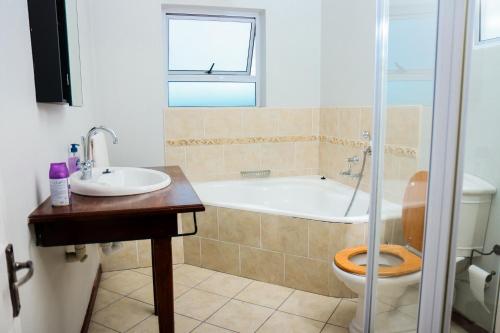 a bathroom with a tub and a toilet and a sink at Santareme Seaviews in Sea Vista