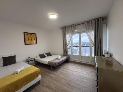 une chambre avec un lit, un canapé et une fenêtre dans l'établissement Le Tempo - 7 pers - Circuit - Rêve au Mans, au Mans