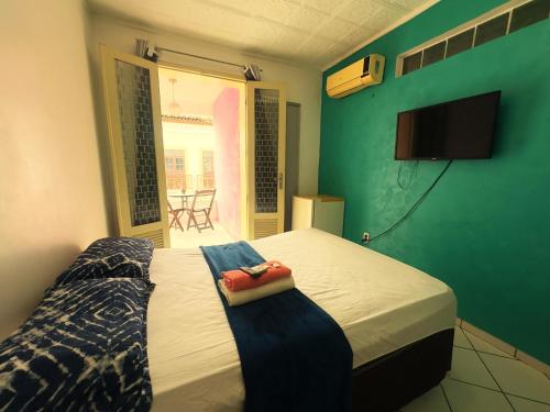 a bedroom with a bed and a window with a chair at Solar dos Poetas in São Luís