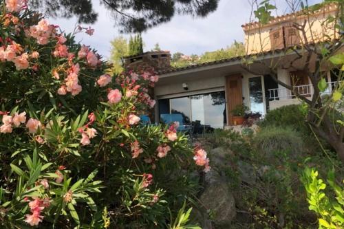 une maison avec des fleurs roses devant elle dans l'établissement Family villa with sea view classified 3 - 8 people, au Lavandou