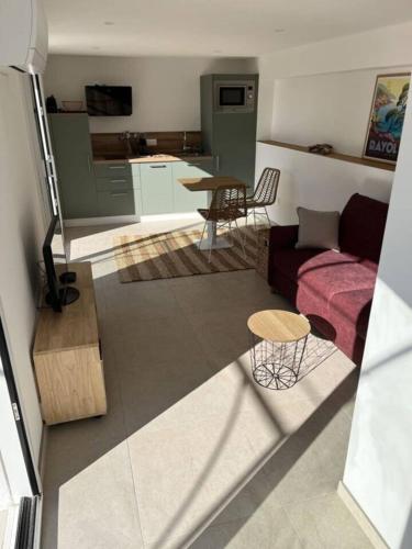 un salon avec un canapé et une table dans l'établissement Sea View Studio with Large Terrace 5-Min Walk to the Beach, au Lavandou