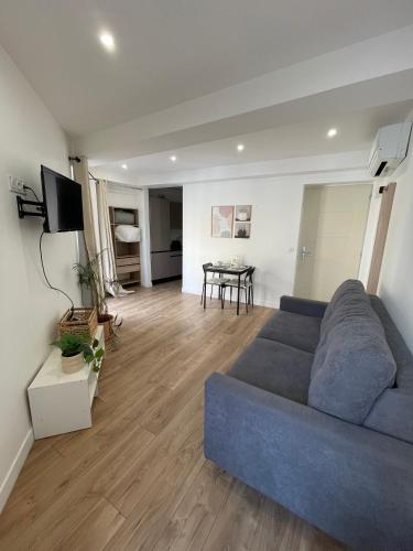 un salon avec un canapé bleu et une table dans l'établissement Joli Studio Place Garibaldi, Vieux-Nice, Port, à Nice