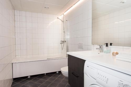 a bathroom with a tub and a sink and a toilet at Svalbard Hotell | Lodge in Longyearbyen