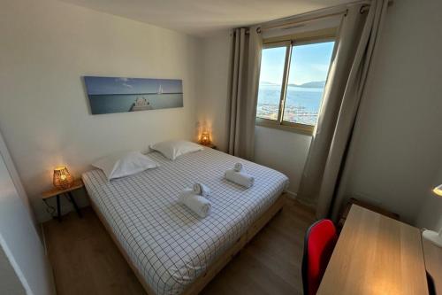 une chambre avec un lit et une grande fenêtre dans l'établissement Résidence Mandariniers - T3 for 4 pers - Piscine, au Lavandou