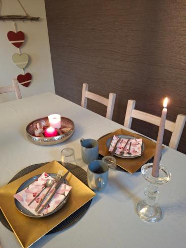 a table with two plates of food and a candle at B&B Caprice d'Epices in Francorchamps