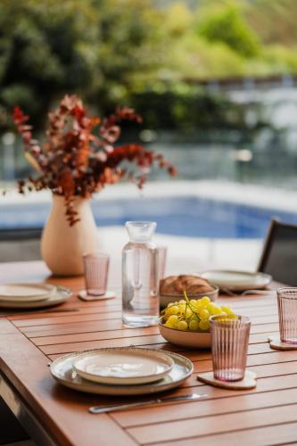 a wooden table with plates of food and a vase at Villa Pattos in Santa Coloma de Farners