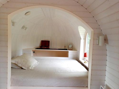 a white room with a bed in an archway at Igloo cabin in Saaremaa in Kapra